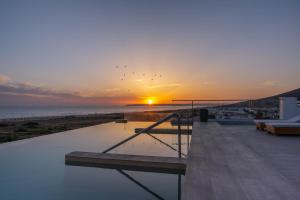 a sunset over the ocean with a swimming pool at Zahara Beach & Spa by QHotels - Adults Recommended in Zahara de los Atunes