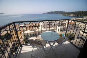 uma varanda com mesa e cadeiras e o oceano em Hotel Svarog em Bečići