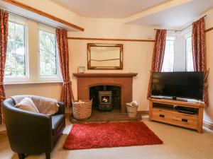 a living room with a television and a fireplace at The Lodge in Penrith