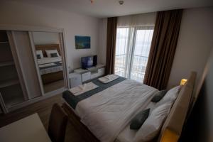 a bedroom with a bed and a large window at Hotel Svarog in Bečići