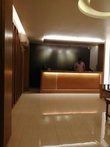 Ein Mann, der hinter einem Tresen in einem Raum steht. in der Unterkunft Hotel Hoque Tower International in Chittagong