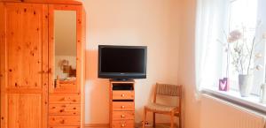 un televisor sentado en la parte superior de un tocador en una habitación en Schöne, helle, ruhige Wohnung und Wellness Sauna 