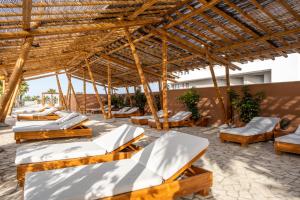 a group of beds under a wooden pavilion at Zahara Beach & Spa by QHotels - Adults Recommended in Zahara de los Atunes