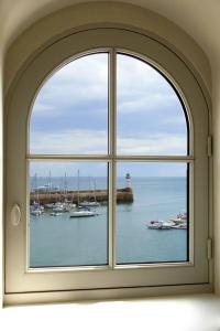 una ventana arqueada con vistas al puerto en Les Appartements d'Alexandre, en Le Palais