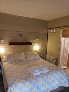 een slaapkamer met een bed met twee handdoeken erop bij De Luna in Puerto Pirámides
