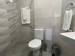a bathroom with a toilet and a sink and towels at HIMS APARTMENTS in Sozopol