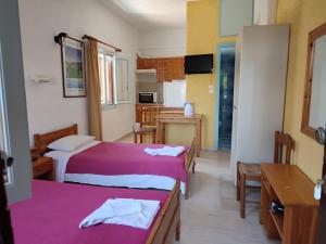 een kleine kamer met 2 bedden en een keuken bij Fotula Studios in Agia Pelagia