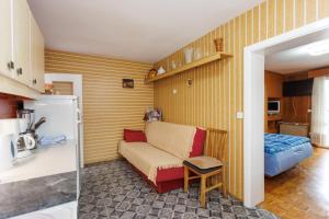 a small room with a couch and a kitchen at Apartments Pika in Krk