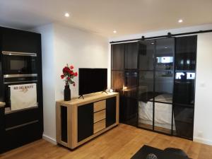 ein Wohnzimmer mit einem TV auf einem Holzständer in der Unterkunft Le Week-End 3 étoiles, plein centre ville in La Clusaz