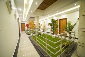 um corredor com plantas no chão de um edifício em Hotel Elite em Amritsar