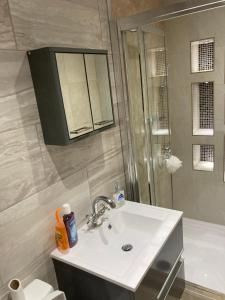 uma casa de banho com um lavatório, um chuveiro e um WC. em London retreat em Golders Green