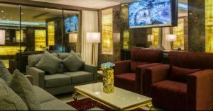 a living room with couches and a tv at Swiss by Pioneer in Jeddah