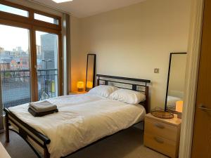 a bedroom with a large bed and a balcony at The Postbox by LFD in Birmingham
