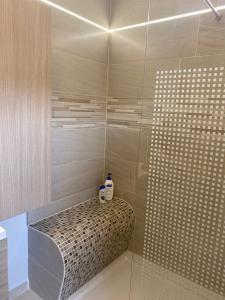 un bagno con doccia e 2 bottiglie sullo sgabello di Maison à 3,2km de l’aéroport a Charleroi