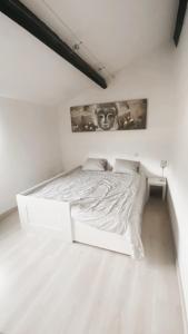 a white bedroom with a white bed in a room at Maison à 3,2km de l’aéroport in Charleroi