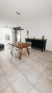 a table and chairs in a room with a piano at Maison à 3,2km de l’aéroport in Charleroi