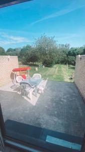 a patio with a table and chairs on a patio at Maison à 3,2km de l’aéroport in Charleroi