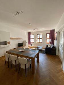 una gran sala de estar con mesa de madera y sillas. en grosszügiges Apartment mit Blick zur Frauenkirche, en Dresden