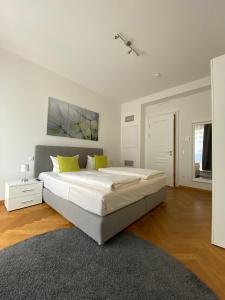 um quarto branco com uma cama grande e almofadas amarelas em grosszügiges Apartment mit Blick zur Frauenkirche em Dresden