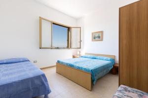 a bedroom with two beds and a window at Casa vacanza Mare Blu in Torre Lapillo +26 photos