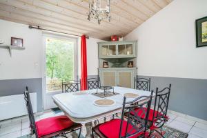 ein Esszimmer mit einem Tisch, Stühlen und einem Fenster in der Unterkunft Le Moulin de Pilet in Mortagne-sur-Sèvre