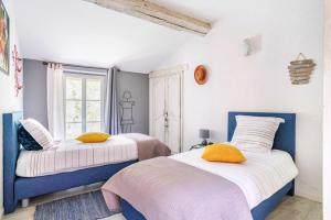 a bedroom with two beds and a window at Le Moulin de Pilet in Mortagne-sur-Sèvre