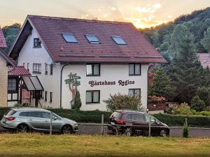 two cars parked in front of a house at Gästehaus Regina in Ruhla