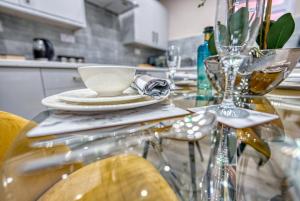 uma mesa de vidro com um prato e um copo sobre ela em Stylish House - B'ham Airport and NEC, JLR Solihull, Business & Leisure Stays - Aspen House em Solihull