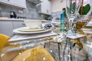 a glass table with a plate and a cup on it at Stylish House - B'ham Airport and NEC, JLR Solihull, Business & Leisure Stays - Aspen House in Solihull