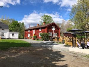 ein rotes Haus mit einem Pavillon davor in der Unterkunft Bredsjö Gamla Herrgård White Dream Mansion in Hällefors