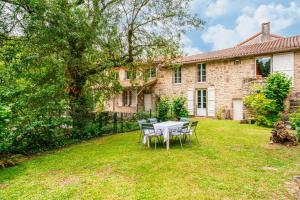 a table and chairs in the yard of a house at Le Moulin de Pilet in Mortagne-sur-Sèvre +11 photos