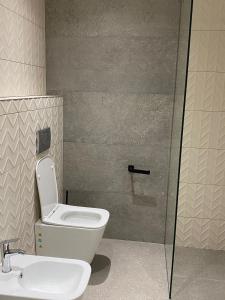 een badkamer met een toilet en een wastafel bij Eval Hotel in Sarandë