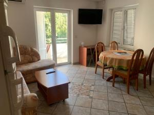 a living room with a table and a couch at Apartmani Auer in Pješčana Uvala