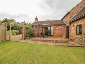 an external view of a brick house with an umbrella at The Cottage in Mapperley