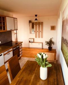 a kitchen with a table with a vase of flowers on it at Urlaub auf Mittelhof in Großenbrode