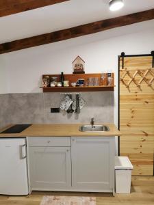 una cocina con armarios blancos y fregadero en Country house en Ankaran