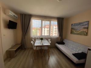 een kleine woonkamer met een tafel en een bank bij Apolon - beautiful apartments 200 m to the beach in Ravda