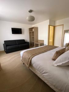 1 dormitorio con 1 cama y 1 sofá negro en Hôtel Le Gois, en Beauvoir-sur-Mer