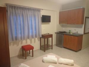 een kamer met een keuken met een wastafel en een tafel bij Nick Rooms in Stavros