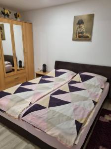 a bedroom with a bed with a checkered blanket at Apartman Nermin in Mostar