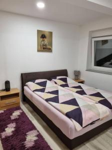 a bedroom with a bed with a black and white comforter at Apartman Nermin in Mostar