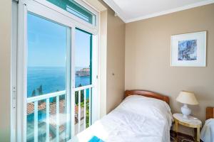 1 dormitorio con cama y ventana grande en Bella Luka Apartment, en Dubrovnik