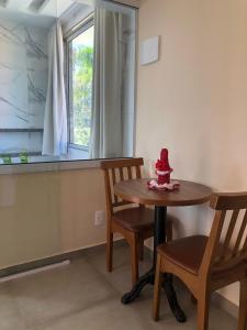 a small table and chairs in a room with a window at Pousada dos Pássaros in Quartéis