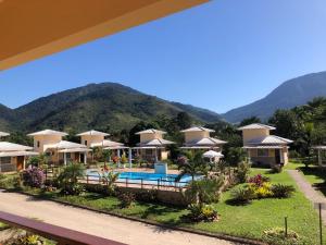 a resort with a pool and mountains in the background at Pousada dos Pássaros in Quartéis
