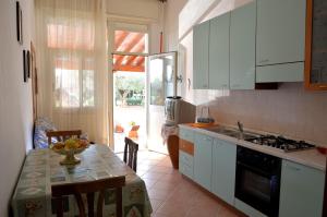 a kitchen with white cabinets and a table with a sink at Sovareto Mare in Sciacca