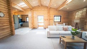 a living room with a white couch in a log cabin at Aspen Lodge, Amazing New Log Cabin with Hot Tub - Sleeps 6 - Felmoor Park in Morpeth