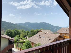 - un balcon avec vue sur les maisons et les montagnes dans l'établissement Appartamento con Terrazzo Panoramico vicino al Centro di Folgaria, à Folgaria