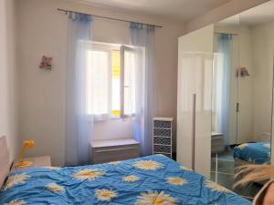 a bedroom with a bed with a blue comforter and a window at Appartamento Il Cigno in Rapallo