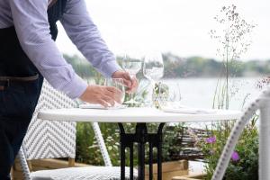 a person holding two wine glasses on a table at Hôtel De La Vallée in Dinard