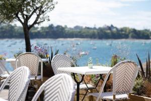 a table and chairs with a view of the water at Hôtel De La Vallée in Dinard